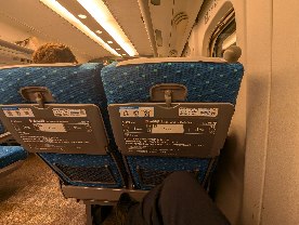 新幹線の座席を後ろから見た写真。前の座席が大きく倒れている